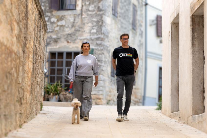 Una coppia con un cane passeggia per le strade di Valle